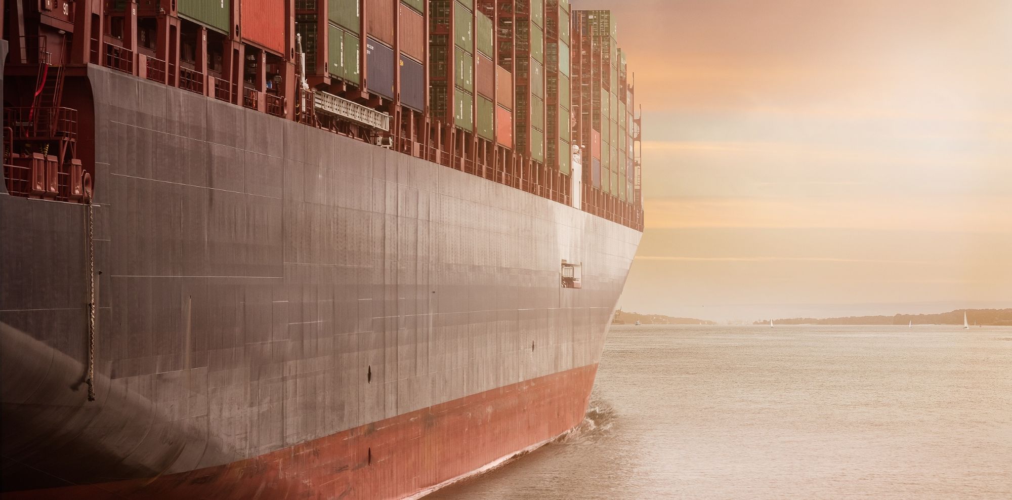 A container ship sailing at sunset